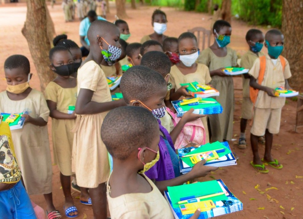 Écoliers tenant des kits de fournitures scolaires