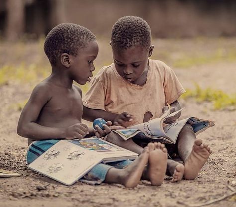 Deux jeunes garçons lisant des livres en plein air